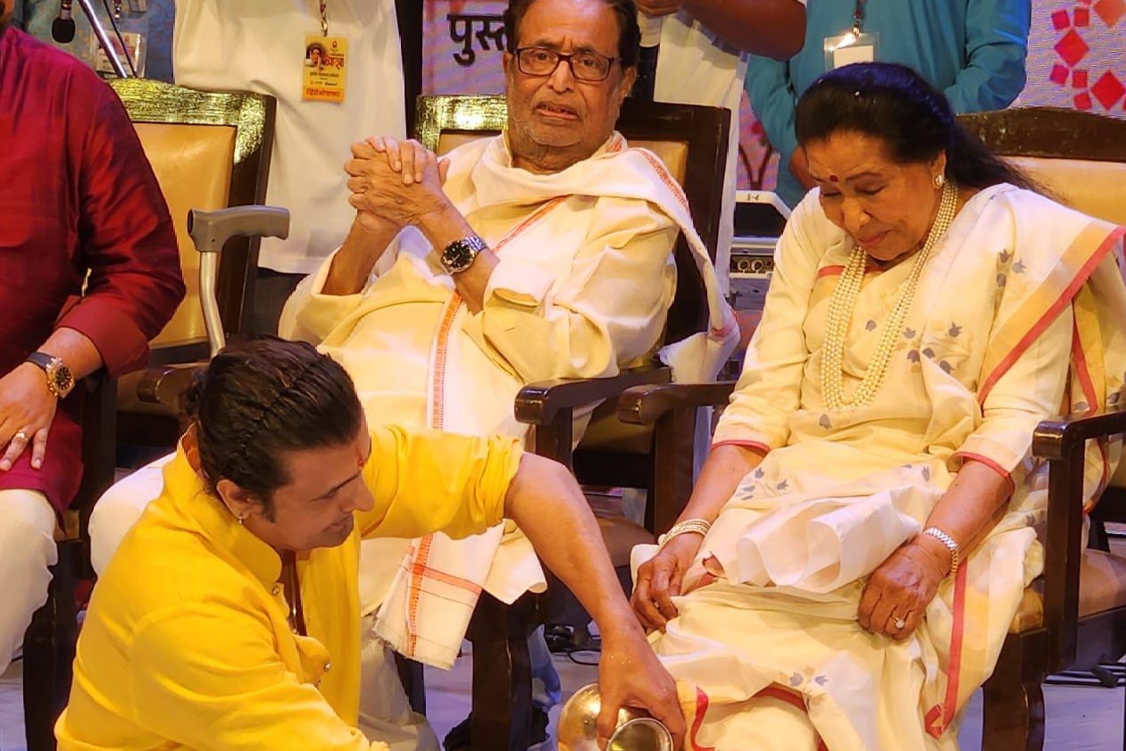 Sonu Nigam washes Asha Bhosle's feet with rose water, petals at book
 launch event