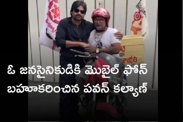 Pawan Kalyan presents a mobile phone to party worker Balaji 