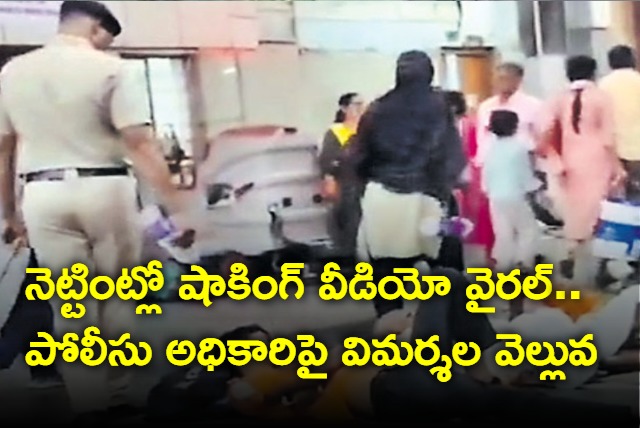 Police officer wakes up passengers sleeping on platform by spraying water on their faces 