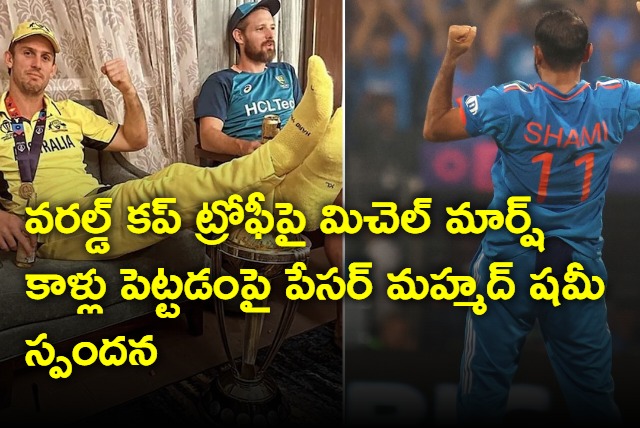 Pacer Mohammad Shami reacts to Mitchell Marsh putting his feet on the World Cup trophy